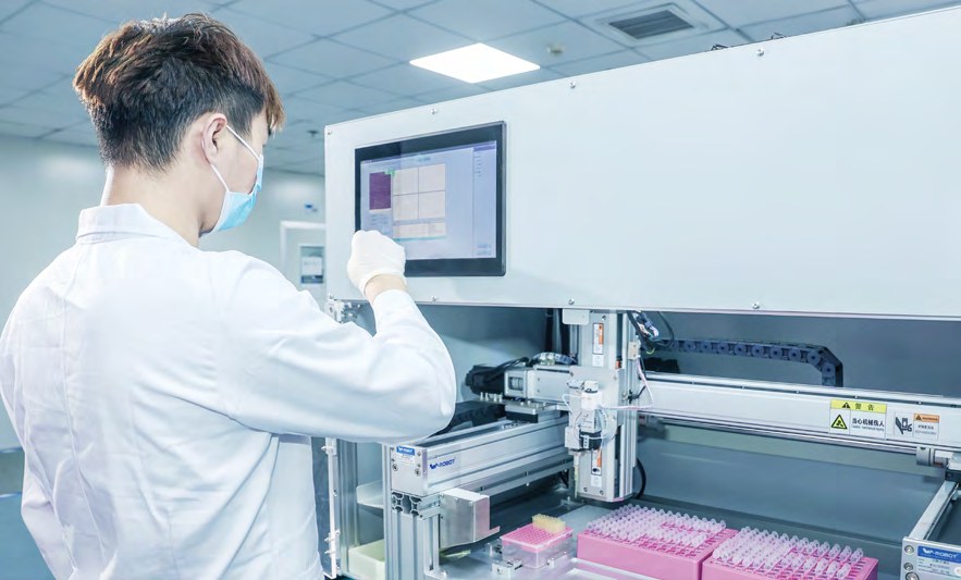 Hero image – technician working at an automated gene synthesis workstation (photo)